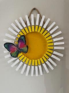 Shows a daisy made from painted clothespins.