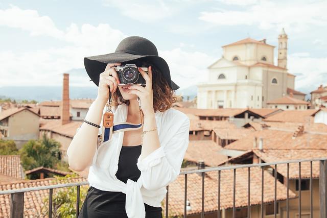 A woman taking a photo with a travel destination in the background